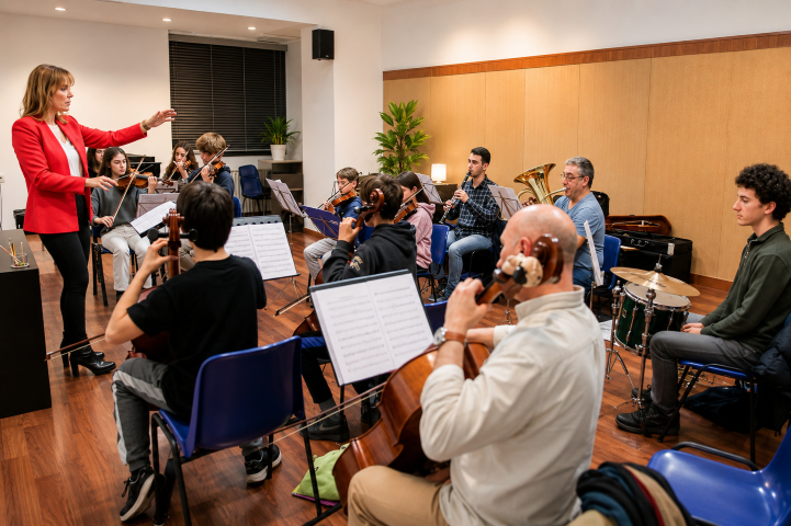 Directora musical dirigiendo un ensayo de orquesta con alumnos y profesores en Musical Martí VAM Madrid.